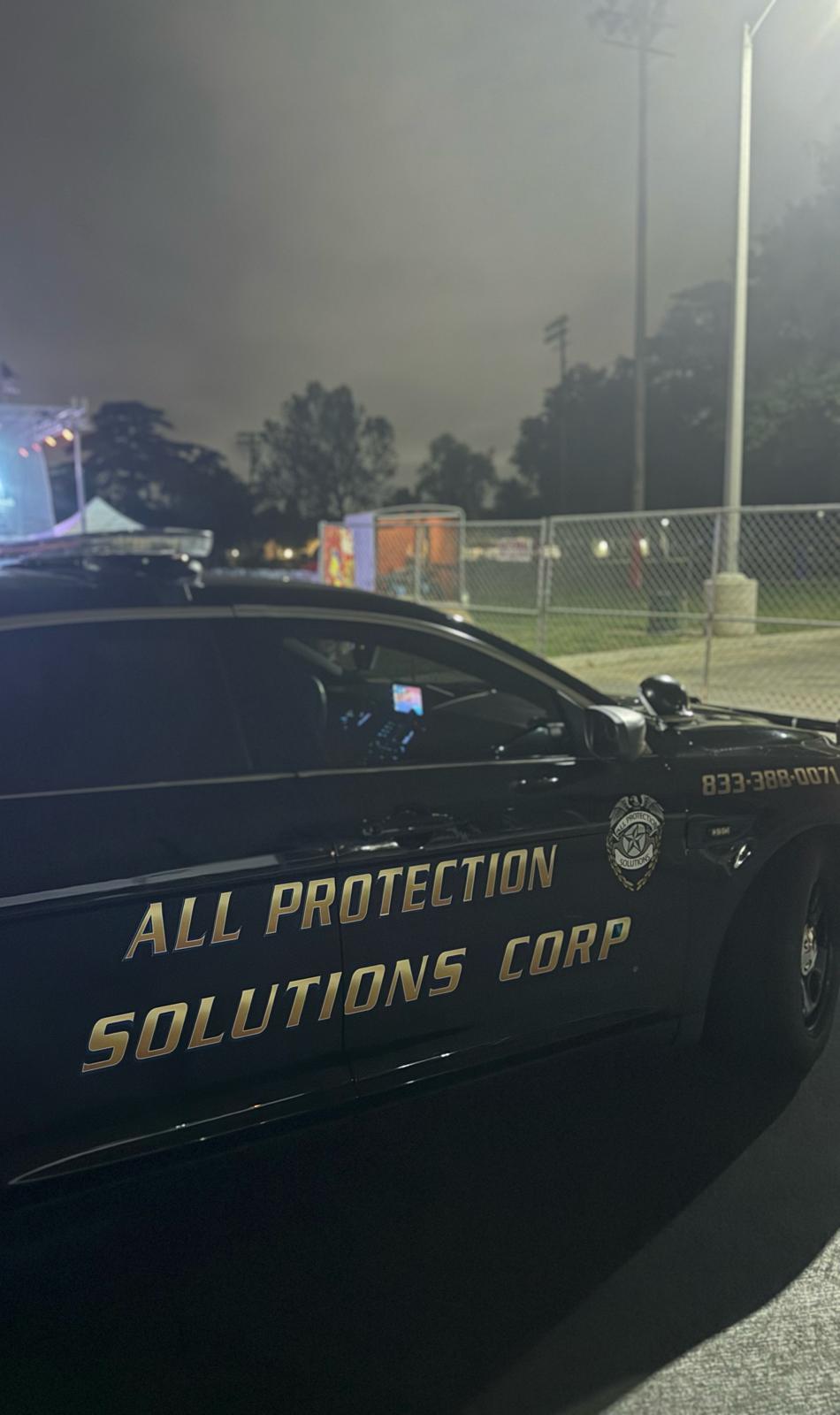 Real APS Security patrol car at a fenced job site at night