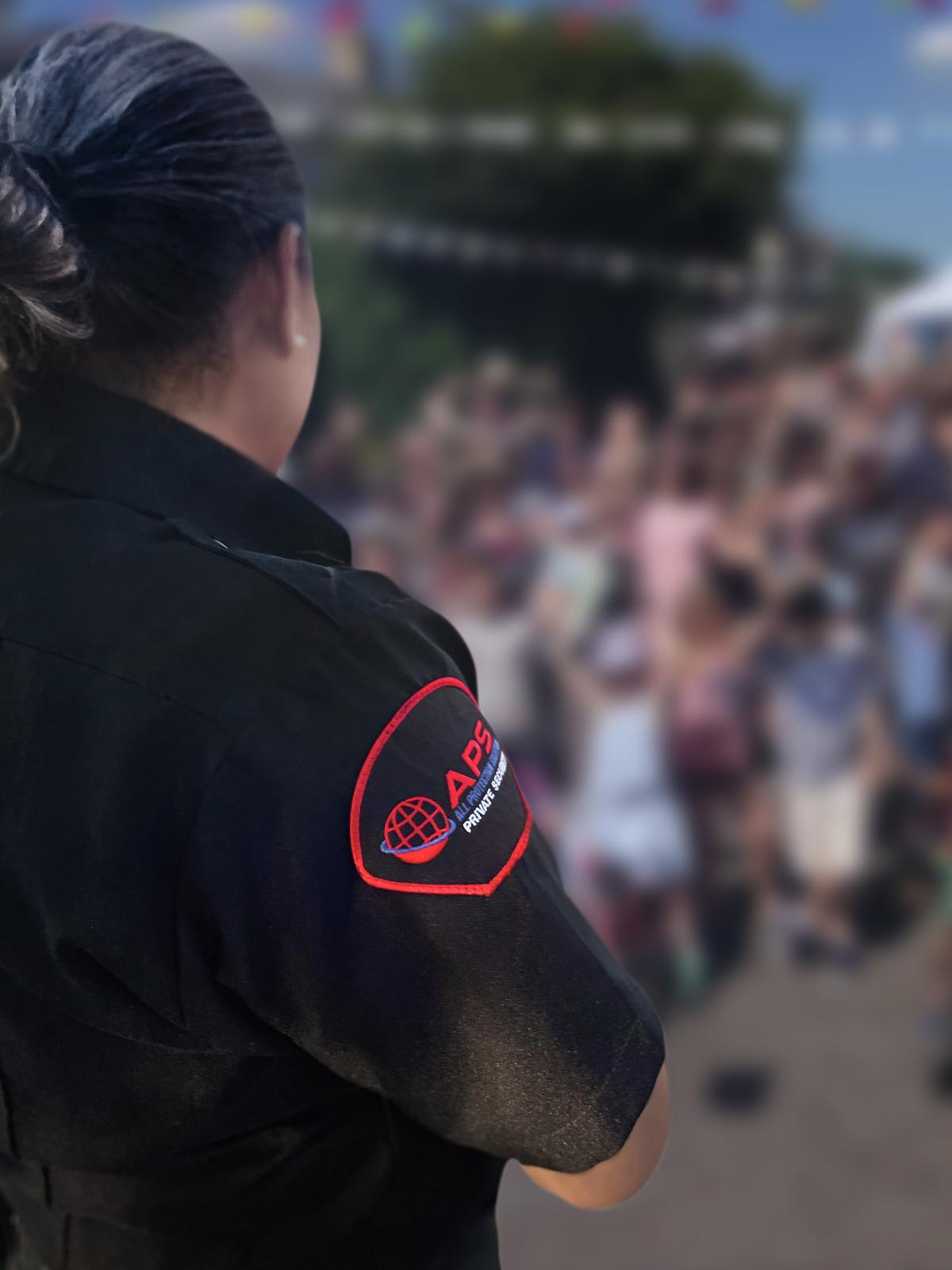 APS event security officer watching a crowd at an outdoor festival